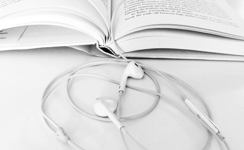 An image of a book and headphones.